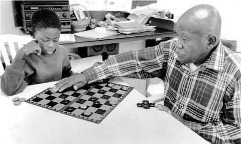 Man and boy play checkers