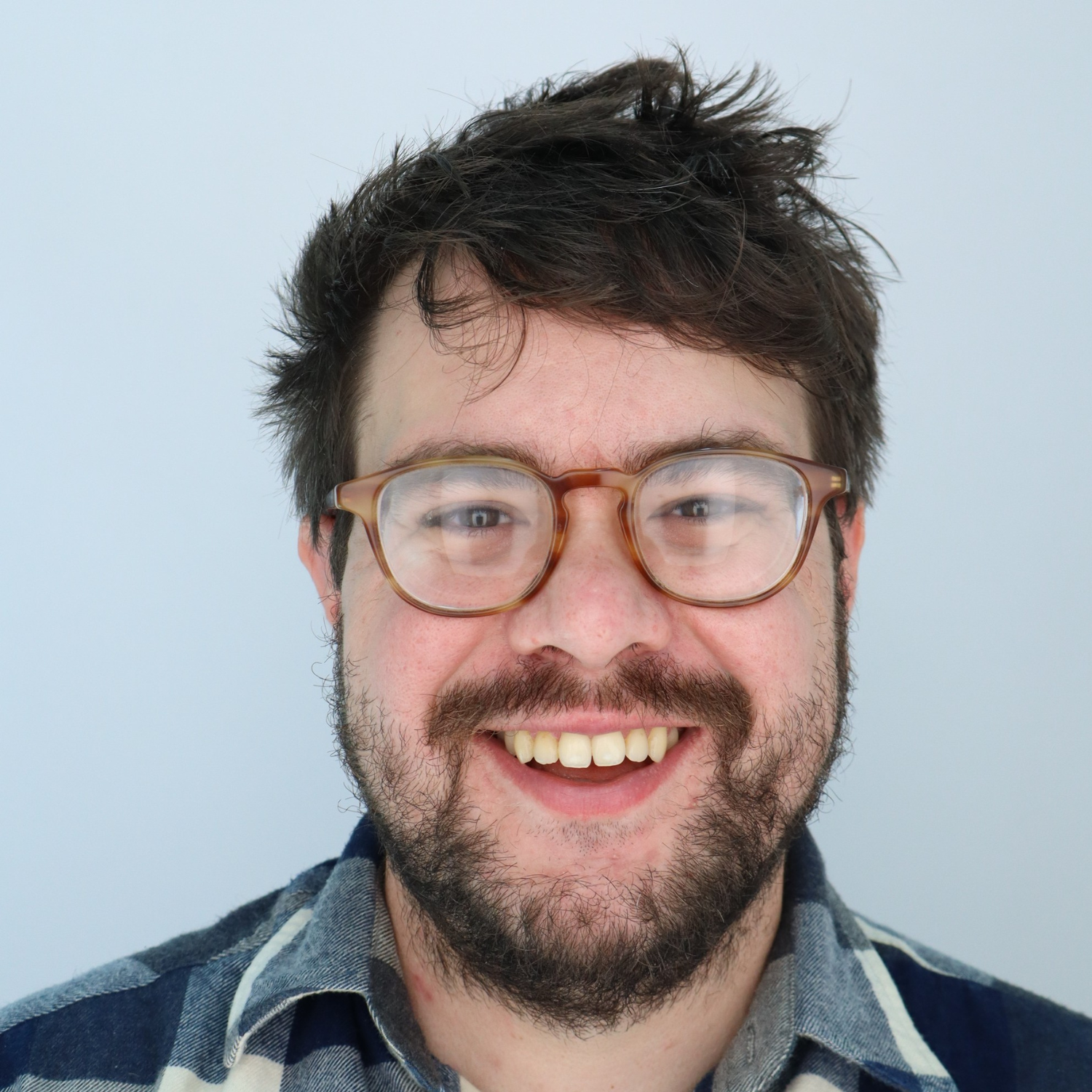 Drew Shaefer's headshot. Drew is a white man with glasses.