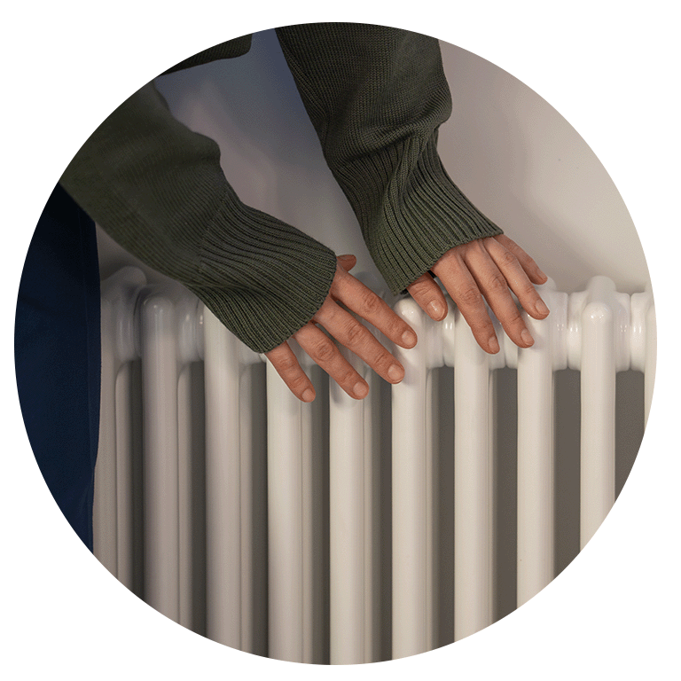 person warming their hands on a radiator