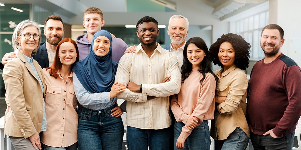 A group of smiling coworkers diverse in race, age and gender.