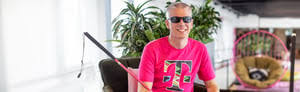  Brand picture from T-Mobile with Keith Clark wearing a pink shirt and Accessibility Community at T-Mobile’s Employee Resource Group’s logo which is a disability pride flag.