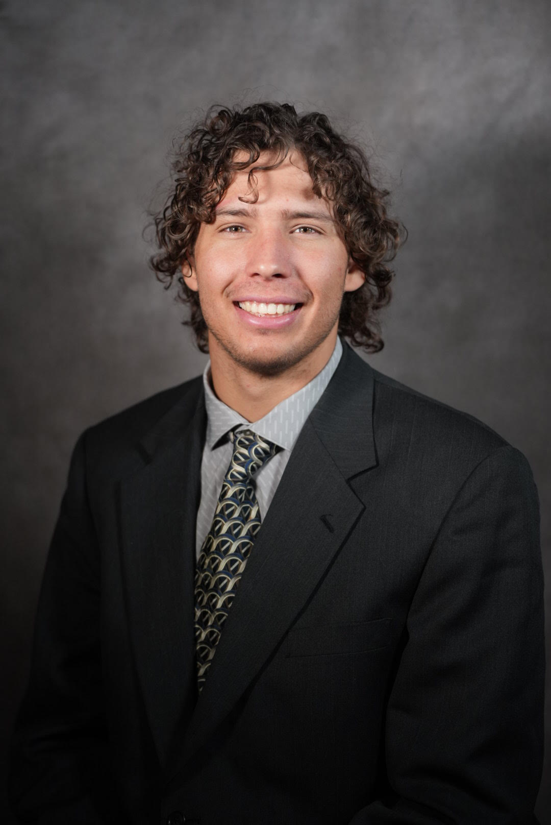 A professional headshot of Kole, smiling. 