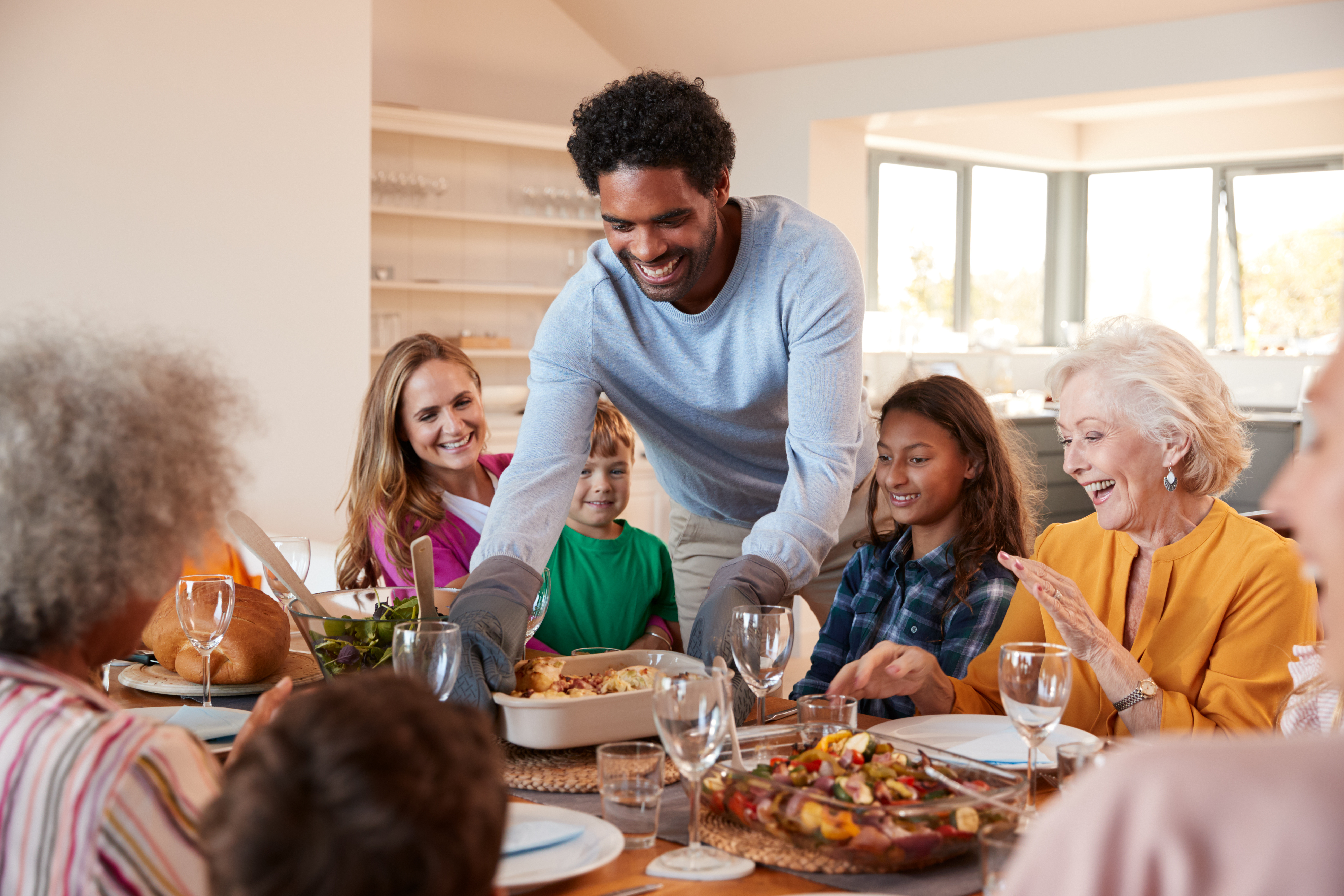 Multi-racial family sitting down for dinner.