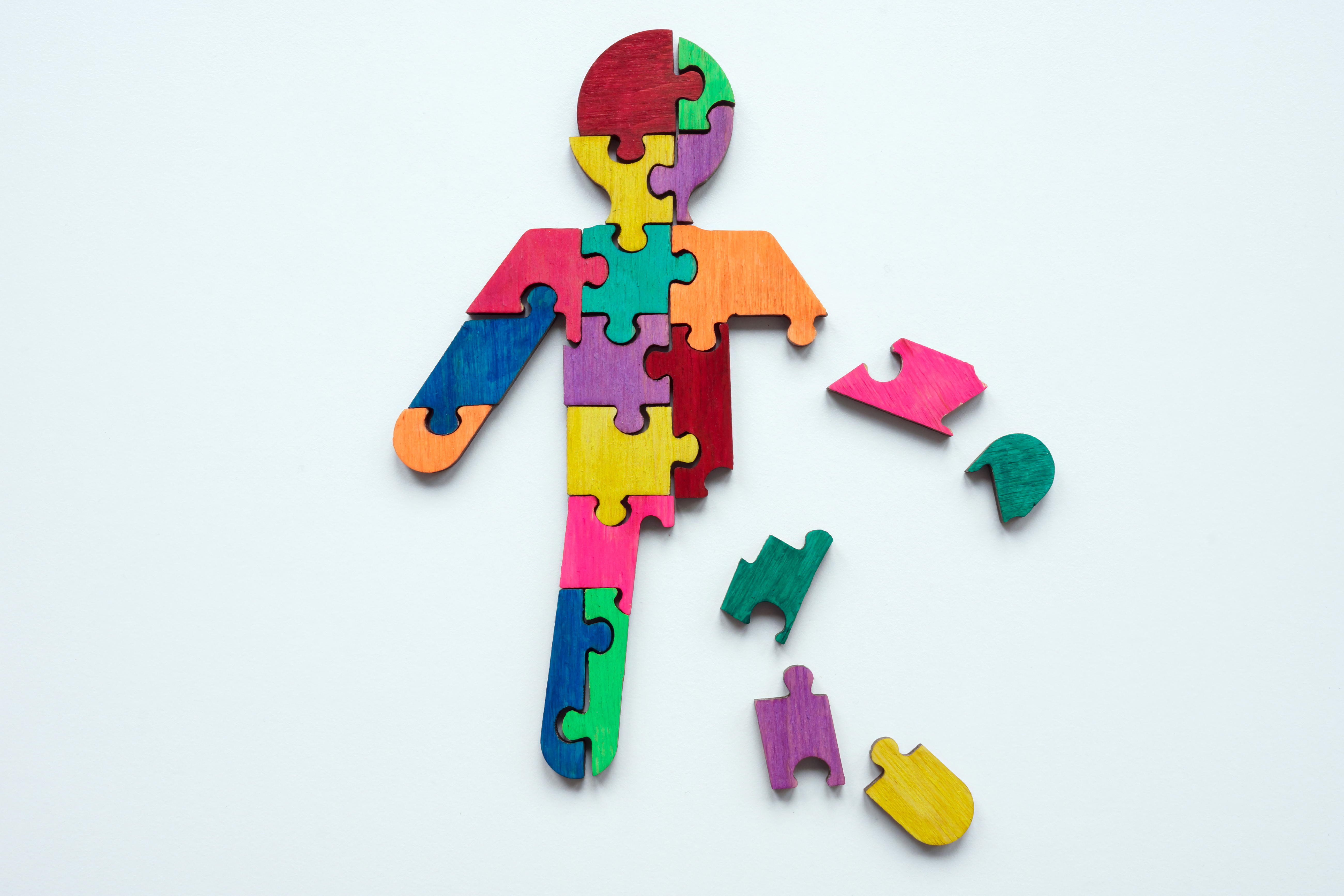 Person-shaped puzzle of brightly colored pieces.
