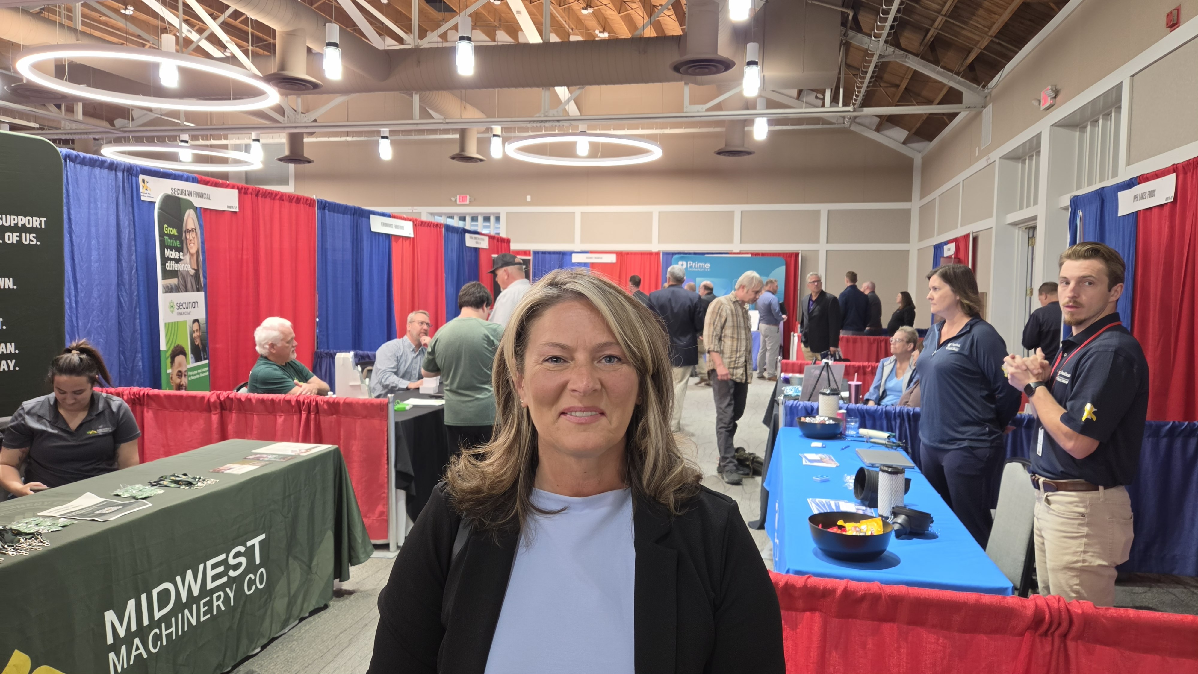 Kathy smiles for a photo. Booths and employers can be seen behind her. Kathy smiles for a photo. Booths and employers can be seen behind her.