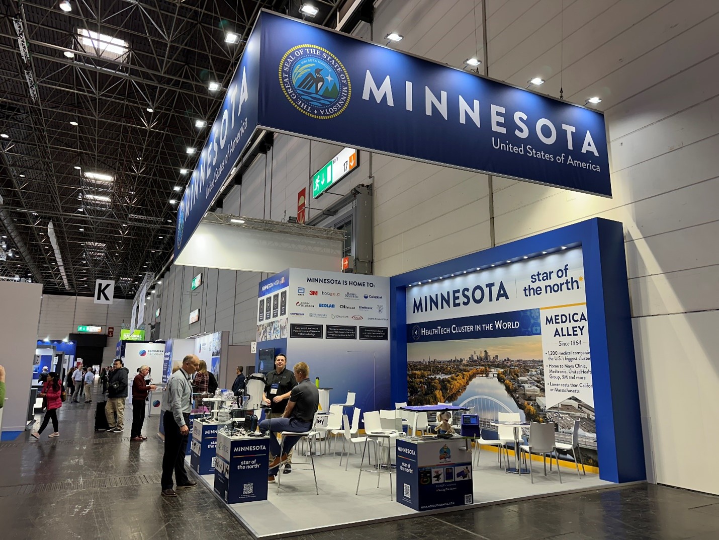 an open-concept booth with tables set for conversations and Star of the North branding.