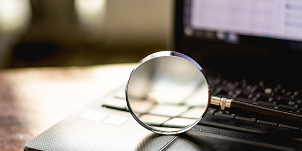 A magnifying glass on a laptop