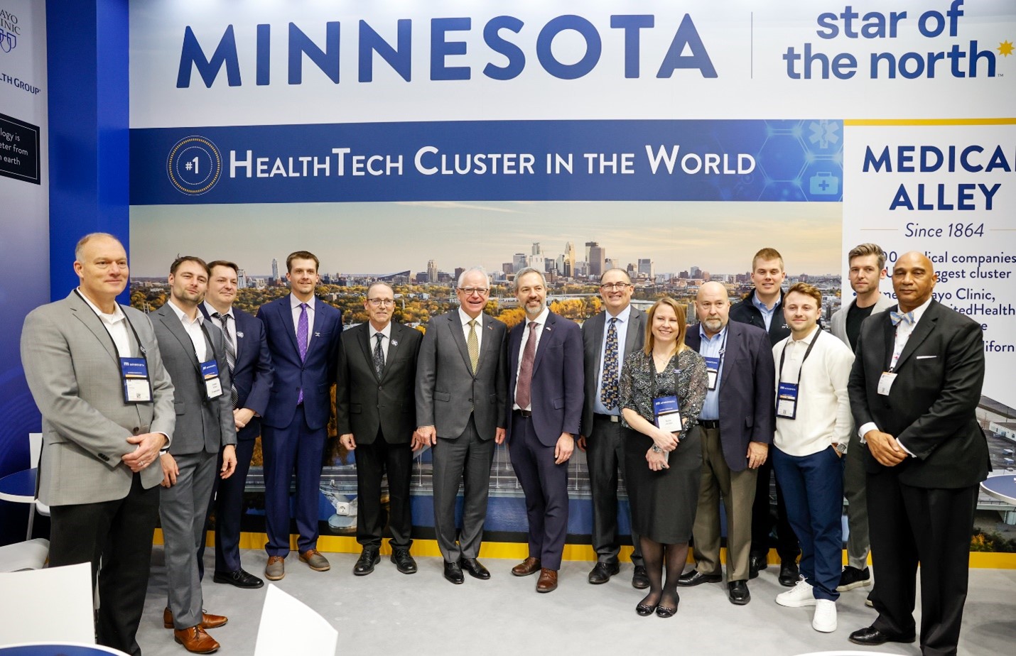 Commissioner Varilek and Governor Walz stand smiling for a picture alongside members of the Minnesota Trade Office team and Communications Team.