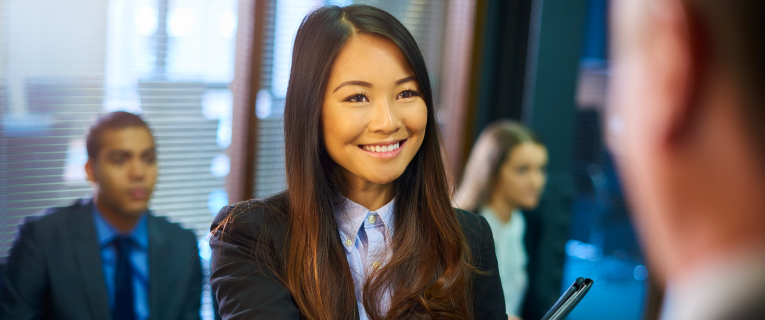 Woman smiling and shaking hands after arriving for an interview.