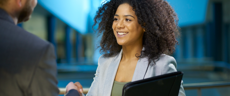 Woman arriving to an interview shaking hand of the interviewer.