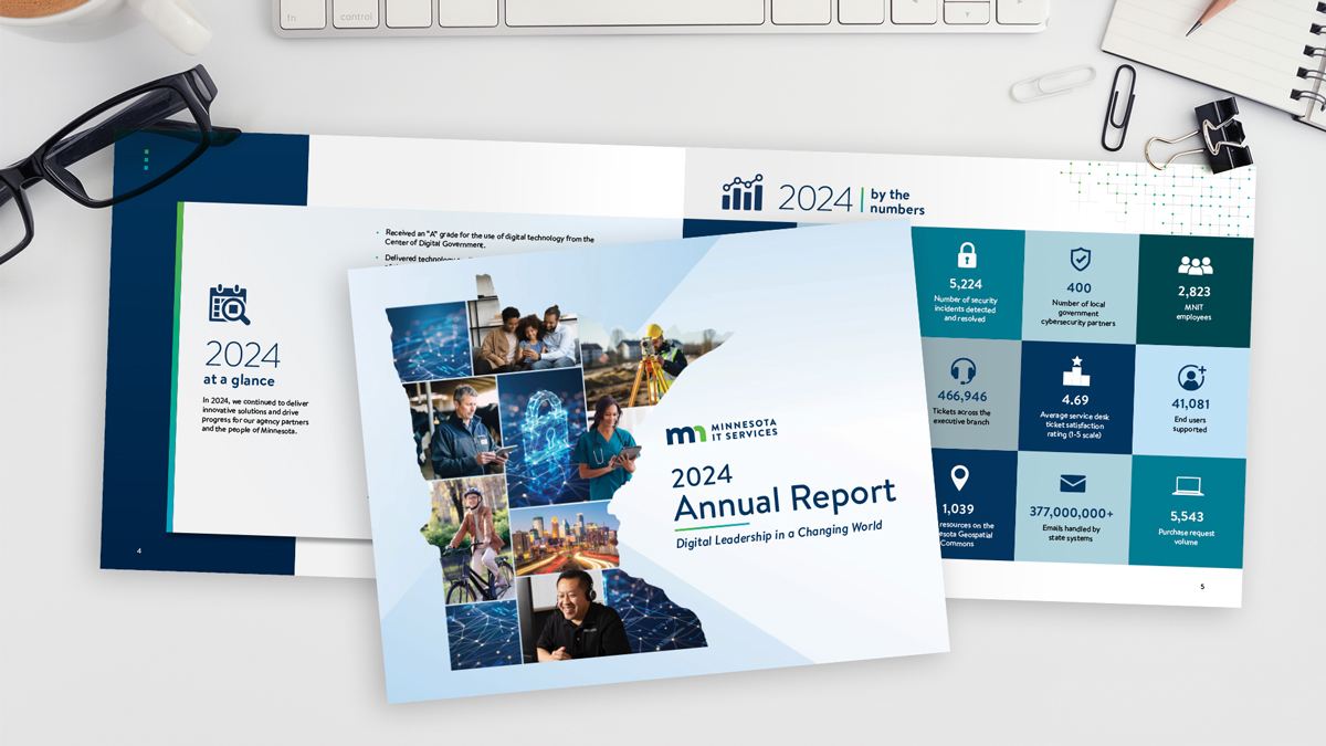 A desktop with office supplies and a copy of MNIT's 2024 Annual Report.