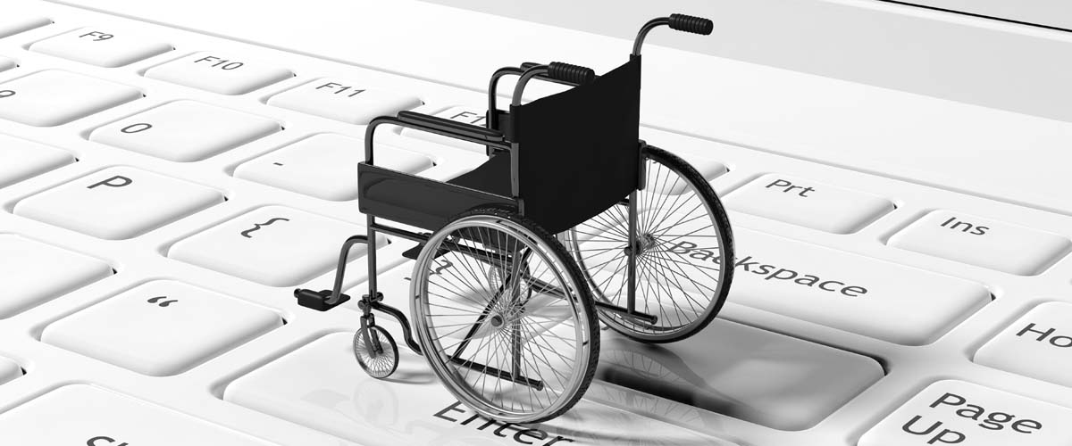 Tiny wheelchair on top of a keyboard.