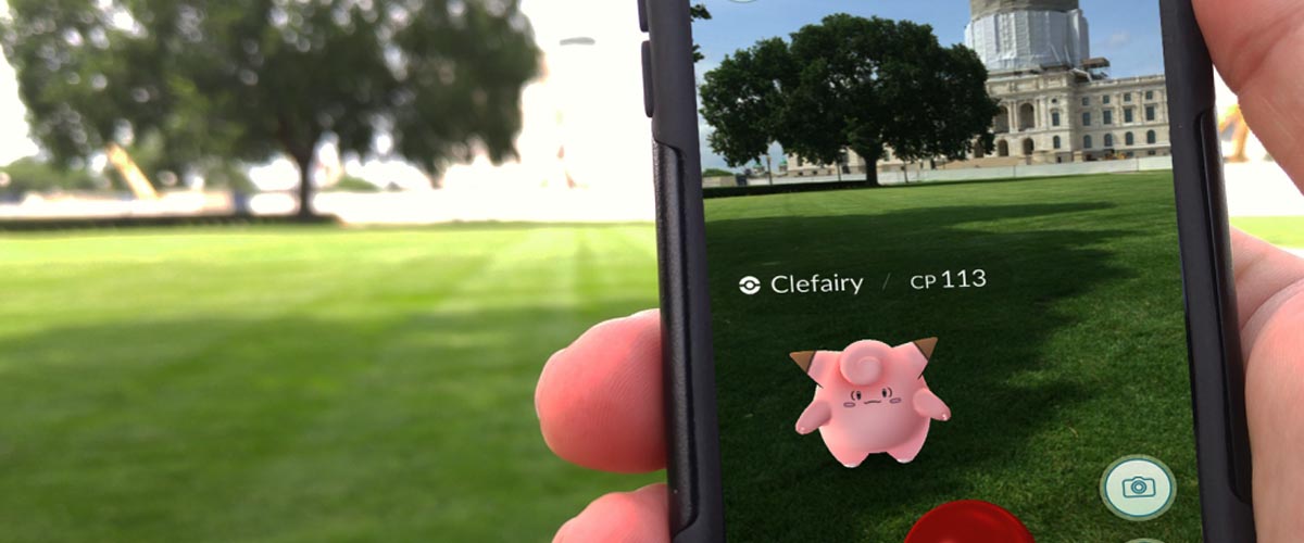 Close up of a person playing Pokemon Go on their cell phone in front of the Minnesota Capitol.