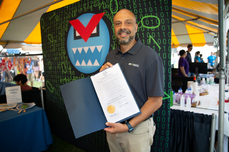 Commissioner Tarek Tomes showing off Governor Tim Walz's STEM Day proclamation 