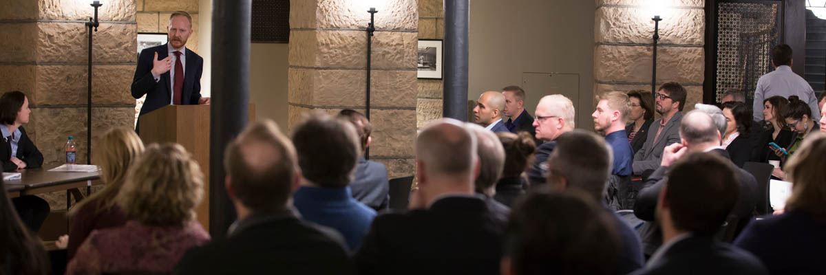 Aaron Call, MNIT's Chief Information Security Officer, speaking at the Cybersecurity Breakfast as the attendees look on.