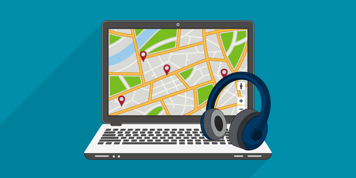 Computer displaying interactive web map, with headphones on keyboard.