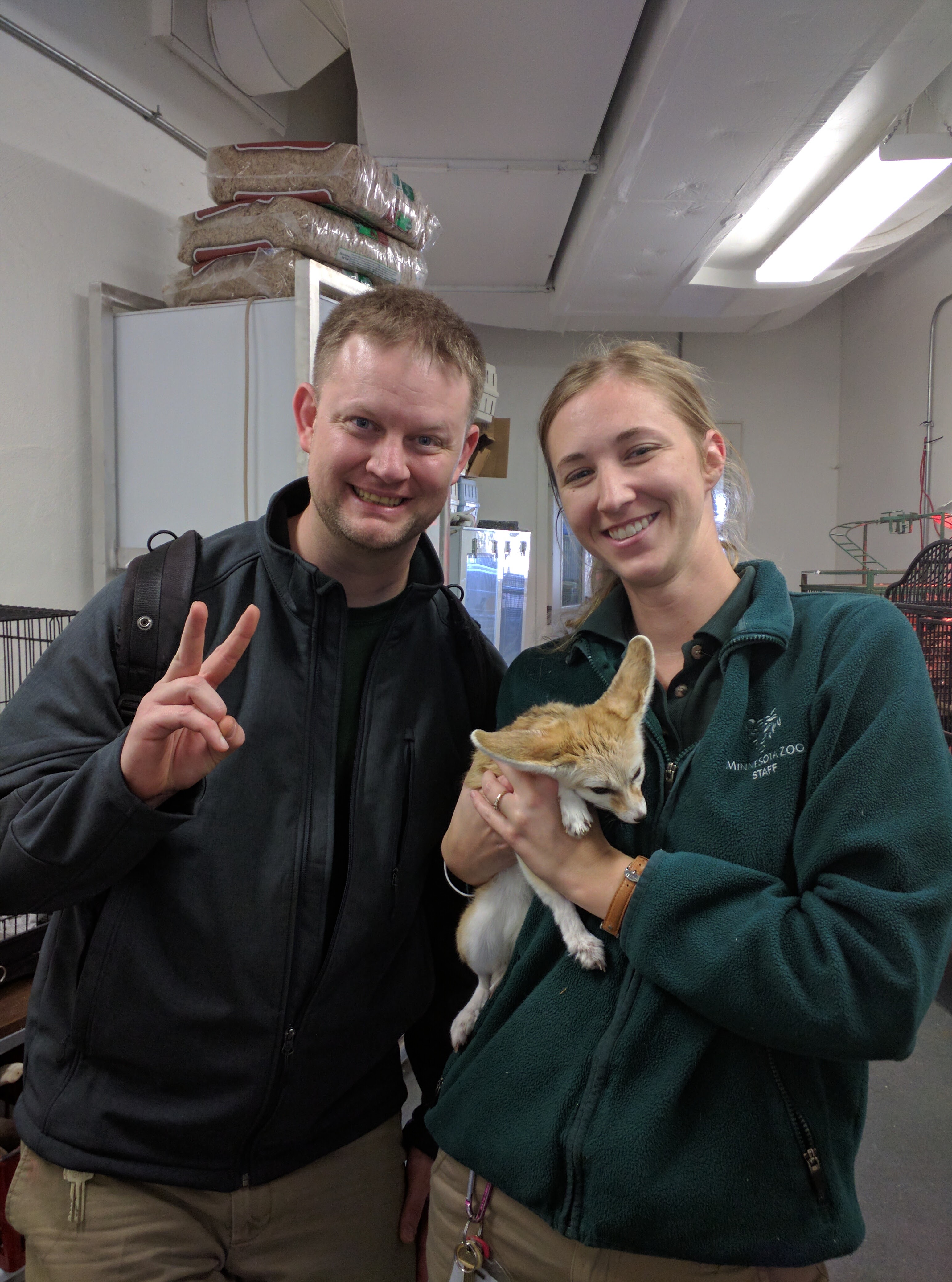 Jeffrey Duvio smiling with a woman holding an animal at the Minnesota Zoo.