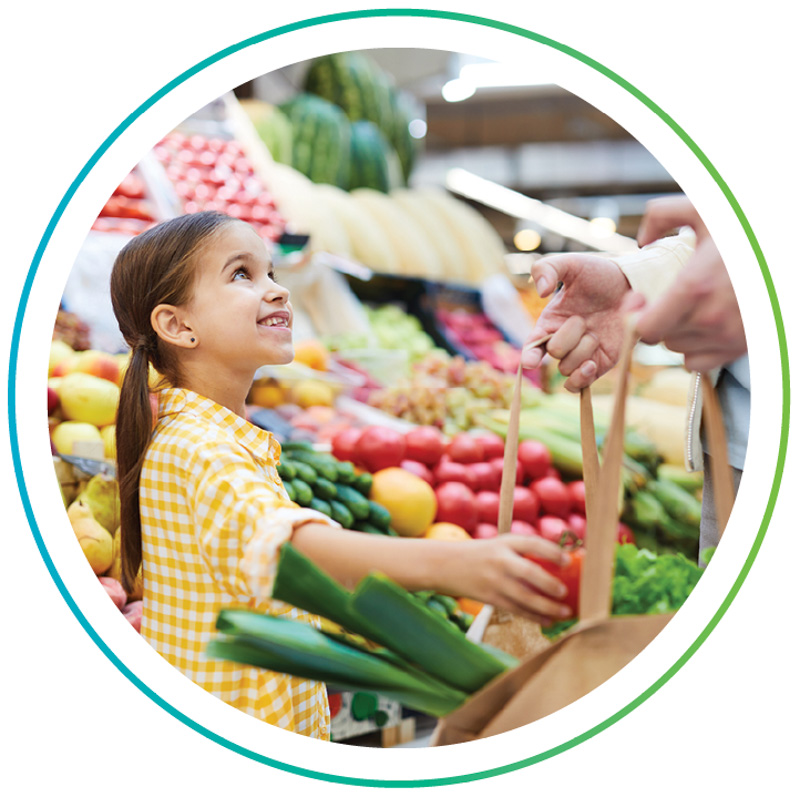A child putting produce into a shopping bag