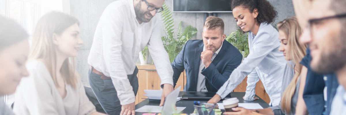 Group of people collaborating around a meeting table.