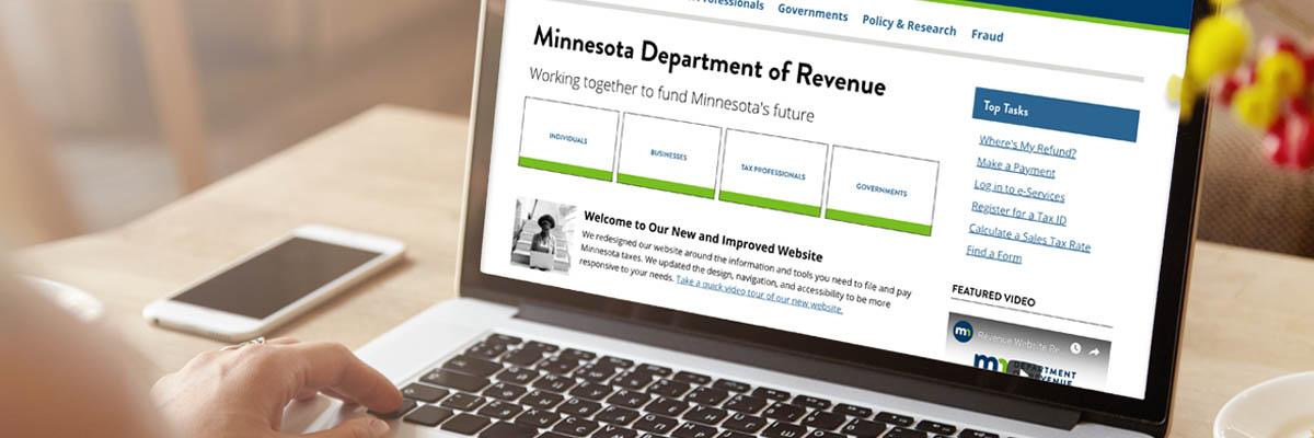 A person looking at the Minnesota Department of Revenue's new website on a laptop.