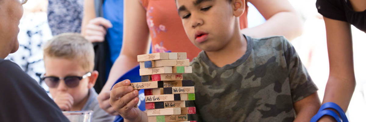 A group of young fairgoers playing cybersecurity Jenga.