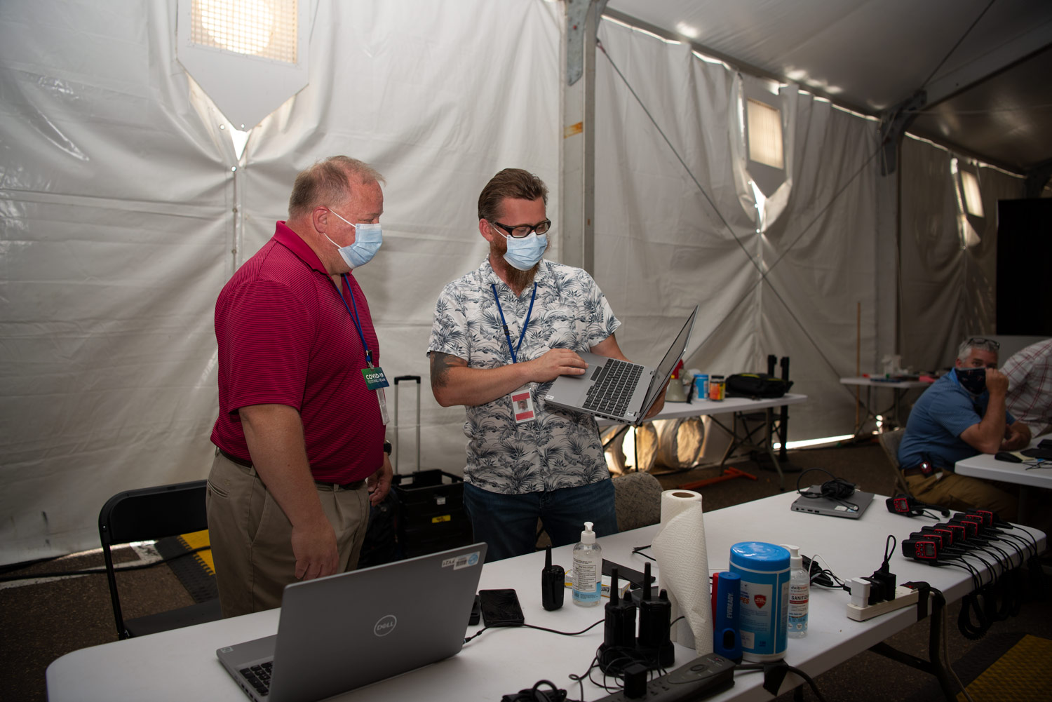 Dave Firkus and Andrew Schuster looking at a laptop at the State Fair community vaccination site.