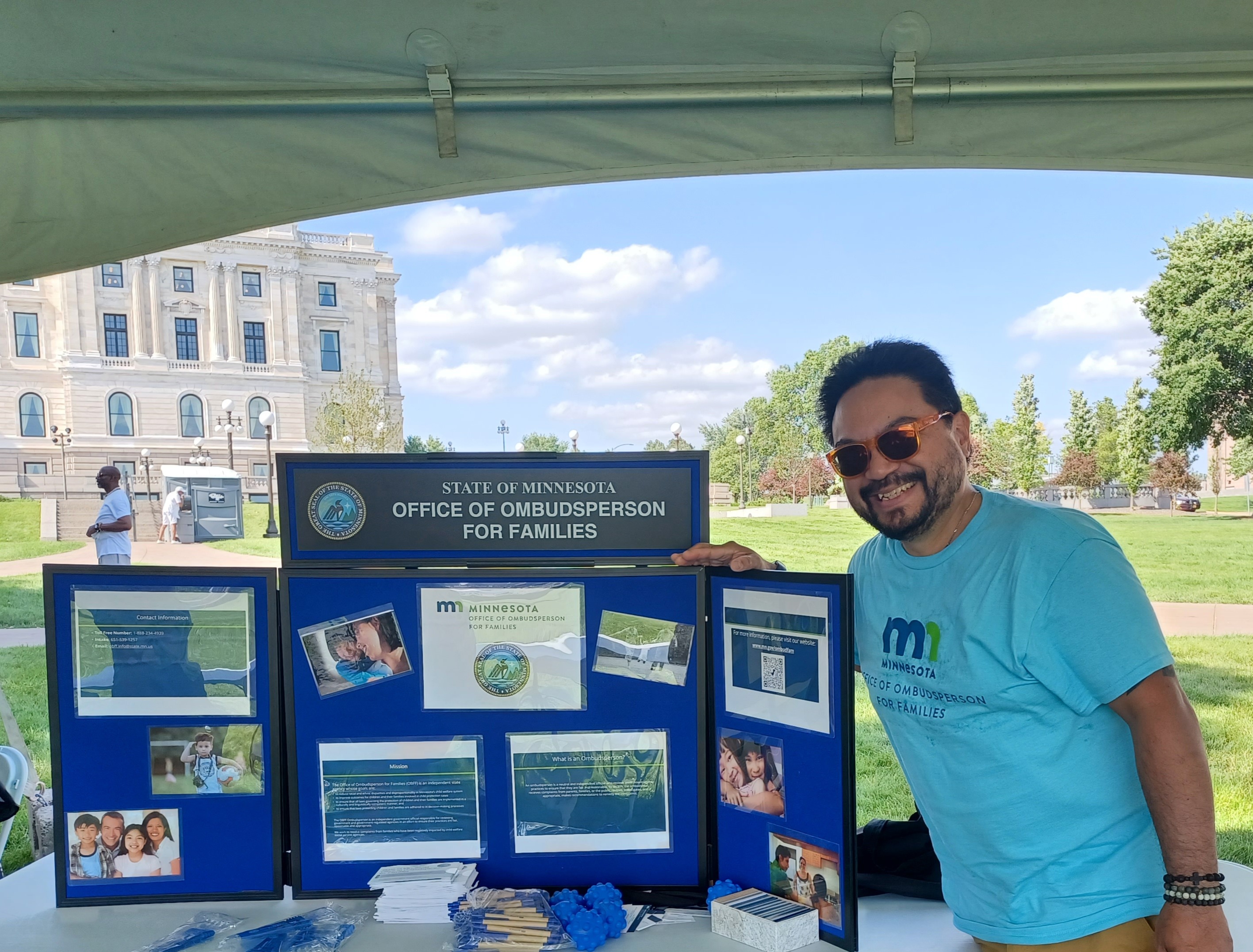 Manuel Zuniga smiles while standing next to the information table for OBFF at the Anika Foundation Juneteenth celebration.