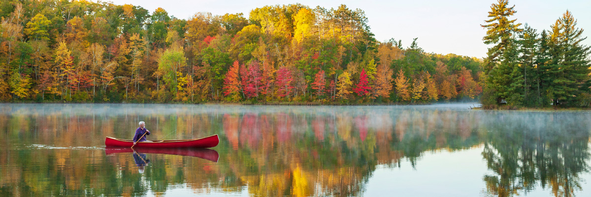 photo of a person canoeing in a lake