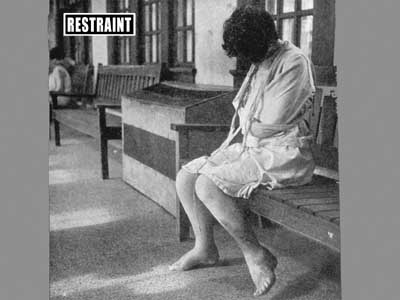 This woman wears a camisole with sleeves tied behind her. Ulcers on her leg are unbandaged.