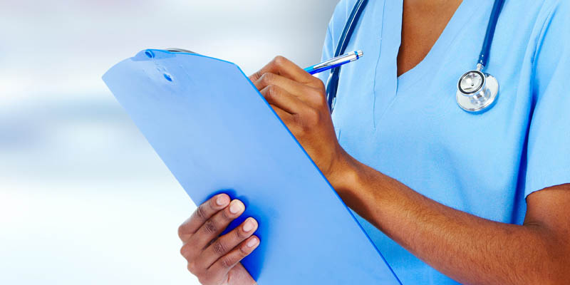 Doctor writing on a clipboard.