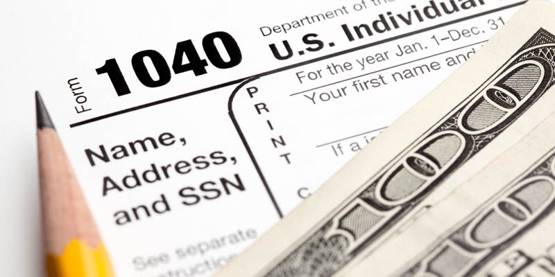 A tax return with pencil and money.