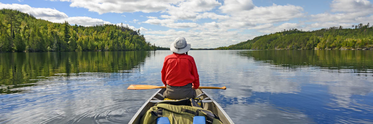 A person paddling a canoe on a lake.